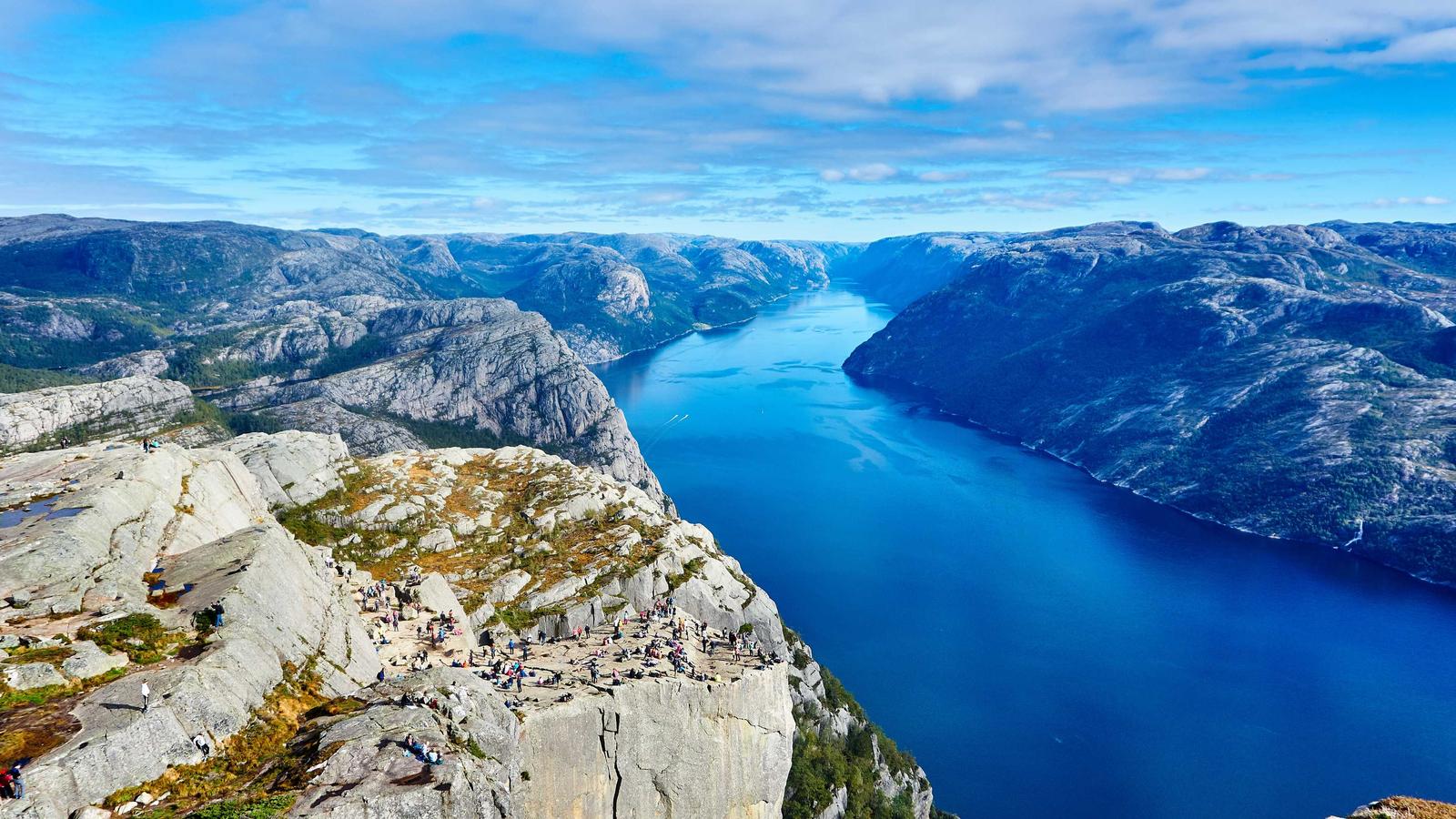 An aerial view of a deep blue fjord flanked by rocky cliffs (stock photo)