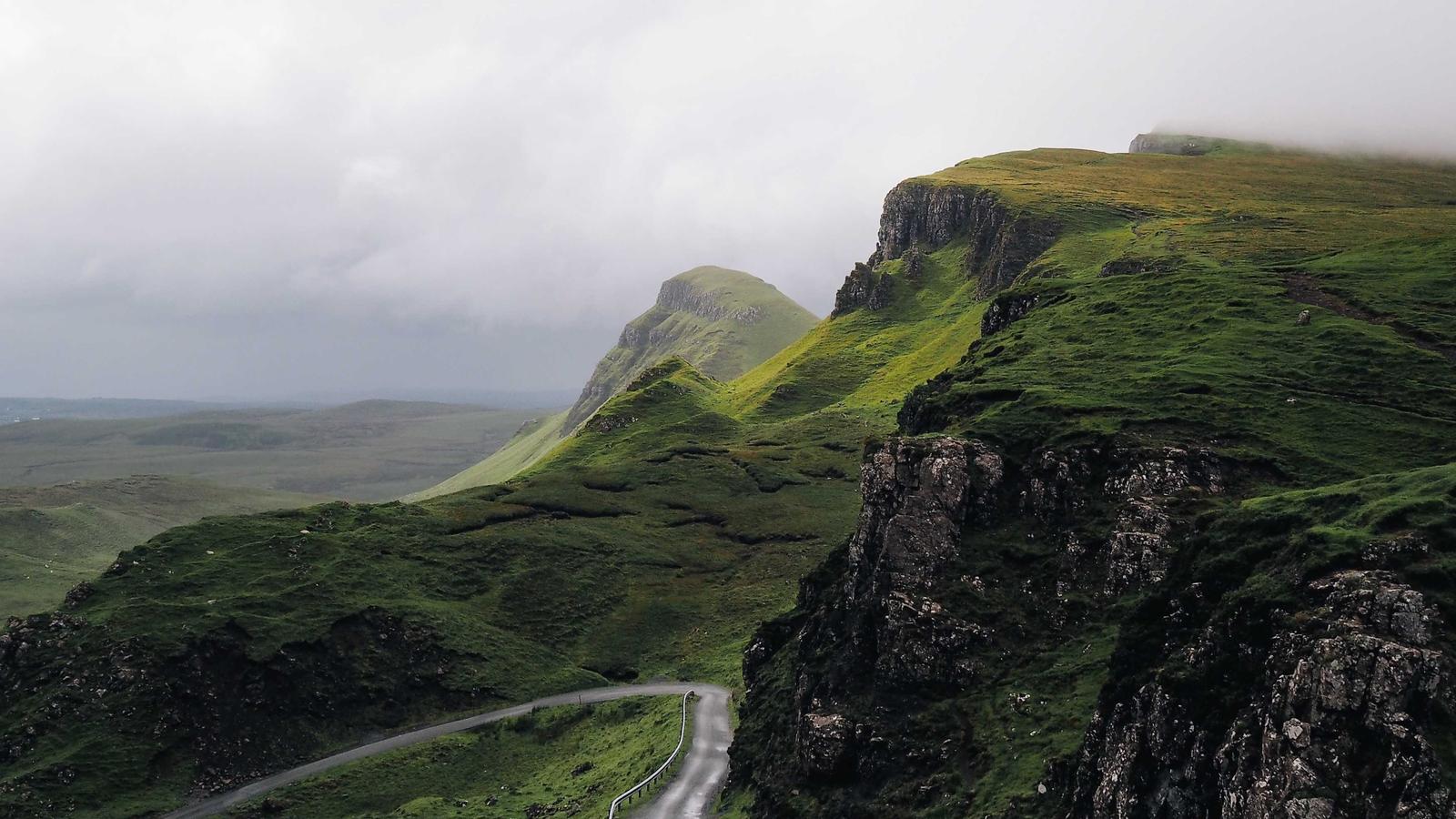 A winding road through green cliffside highlands (stock photo)