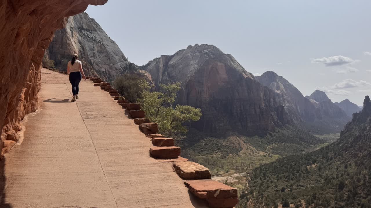 Hiker on a trail above Zion Canyon