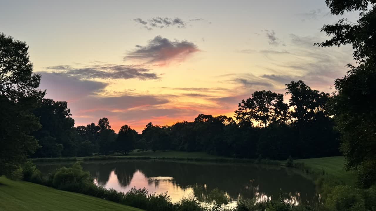 Sunset over a tree-lined pond